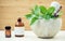 Alternative health care and herbal medicine .Fresh herbs and aromatic oil with mortar and pestle on wooden background. Various he