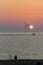 Alternative lifestyle. Peaceful fisherman at sunrise. Green energy wind turbines and solar power