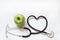 Alternative medicine healthy sign concept with stethoscope heart and green apple on white background