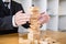 Alternative risk concept, plan and strategy in business protect with balance wooden stack with hand control risk shape