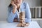 Alternative Risk and Strategy in Business, Image of Stressed, worry, Business woman gambling placing making wooden block hierarchy