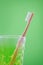 Alternative wooden toothbrush in a glass on green background, vertical