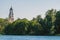 Aluksne Evangelical Lutheran Church tower above the tree tops, view from the lake