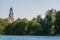 Aluksne Evangelical Lutheran Church tower above the tree tops, view from the lake, Aluksne, Latvia