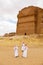 AlUla, Saudi Arabia, February 19 2020: Three Saudis stand in front of the tomb of Lihyan son of Kuza