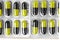 Aluminum blisters with colored black and yellow oval capsules neat flat lay