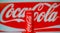 Aluminum can of non-alcoholic carbonated beverage Coca-Cola against the background of advertising poster of brand Coca-Cola in Rus