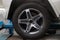 Aluminum rim of a car with a dressed rubber black tire on a car in the back of a white crossover in a vehicle repair workshop