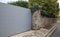 Aluminum Sliding Modern Gray Portal Design Suburban Slide House Garden Door. Stone Fence with Metal Gates for Access to a House in