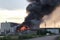 aluminum smelter, with flames and smoke rising from the facility