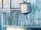 Aluminum washbasin hanging on peeling blue wooden wall