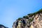 Amalfi city minimalistic view to the church green dome roof with tile patterns and rock cliff mountains. Amalfitana