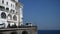Amalfi, Italy - 3 September 2023. Driving cars and walking people on road of Amalfi coast on background beautiful