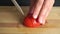 Amateur cooking of Greek salad. Part of the set. Man cutting red tomato