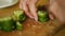 Amateur female cooker cutting cucumber