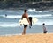 Amateur surfer is walking on the beach with his surfboard