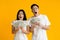 Amazed asian couple holding bunch of money banknotes