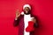 Amazed Black man holding holiday presents inside christmas sock, showing ok sign in approval, like something, standing