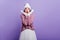 Amazed caucasian girl in winter outfit posing in studio with purple interior. Surprised young woman in white skirt and