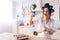 Amazed cheerful young woman look at yellow eggs that she blend. Stand in kitchen and wonder. Eggs in container on table