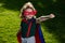 Amazed child superhero hero in red cloak in nature.