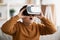 Amazed chubby boy with VR glasses, home interior