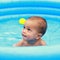 Amazed cute baby boy in blue inflating pool