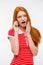 Amazed excited redhead woman talking on mobile phone