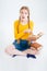 Amazed female student sitting on the floor with book