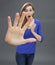 Amazed girl with large hand forward for concept of caution