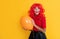 amazed girl with party balloon on yellow background