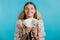 Amazed happy excited woman with money - U.S. currency dollars banknotes on blue wall. Symbol of success, gain, victory.