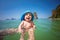 Amazed infant baby of seven months bathes in the sea for the first time. Sunny day, dad holds the baby. Only hands of man