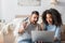 amazed interracial couple looking at laptop