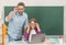 amazed kid and dad sitting in classroom with computer at blackboard, e-learning