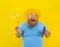 Amazed man with yellow wig in head play with bubbles soap