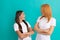 amazed mom and daughter with straight hair in white shirts crossed hands, amazement