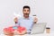 Amazed shocked man holding paper airplane and bank card, sitting in office workplace with rubber ring