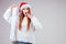 Amazed and surprised redhaired ginger woman wearing red santa claus hat and knitted sweater holding long shopping