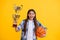 amazed teen basketball girl hold her award cup isolated on yellow. teen basketball girl receive award in studio. teen