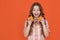 amazed teen girl hold citric fruit on orange background