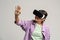 Amazed teenage girl using virtual reality glasses, playing video game using vr goggles isolated