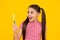 Amazed teenager. Funny teen girl brush her teeth, dental healthy concept, isolated over yellow background. Healthy kids