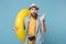Amazed traveler tourist man in yellow clothes with photo camera isolated on blue background. Passenger traveling abroad