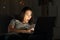 Amazed woman watching online content in the dark