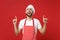 Amazed young bearded male chef cook baker man in striped apron white t-shirt toque chefs hat posing isolated on red