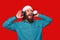 Amazed young man with beard listening music at headphones and wearing santa claus hat
