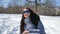 Amazing adult girl in blue mirrored sunglasses and straight dark hair throwing snowballs playing with somebody outdoors