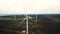 Amazing aerial panoramic view of windmill turbine farm generating power in autumn forest lake field, eco-friendly energy
