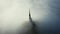 Amazing aerial shot of thick fog covering majestic Mont Saint Michel fortress castle spire at sunrise in Normandy France
